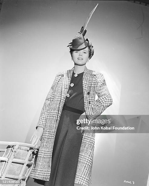 Actress Mary Astor , in a promotional shot wearing a long feathered hat, circa 1930-1945.
