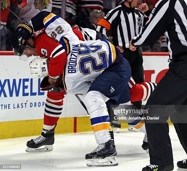 Kyle Brodziak of the St. Louis Blues and Viktor Svedberg of the Chicago Blackhawks fight in the first period in Game Three of the Western Conference...