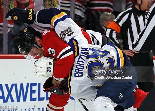 Kyle Brodziak of the St. Louis Blues and Viktor Svedberg of the Chicago Blackhawks fight in the first period in Game Three of the Western Conference...