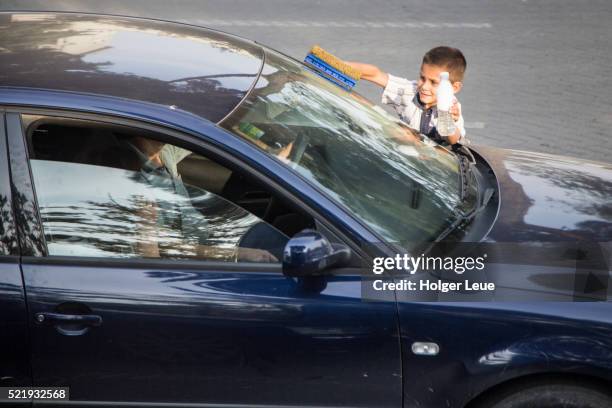 young boy washes windscreen of car - child labour stock pictures, royalty-free photos & images