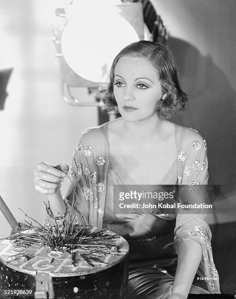 Actress Tallulah Bankhead , in a promotional shot for Paramount Pictures, wearing a nightgown and playing a board game, 1932.