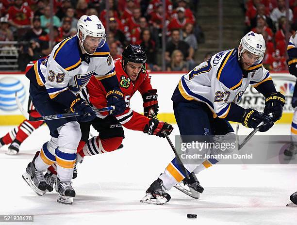 Andrew Shaw of the Chicago Blackhawks chases the puck between Troy Brouwer and Alex Pietrangelo of the St. Louis Blues in Game Three of the Western...