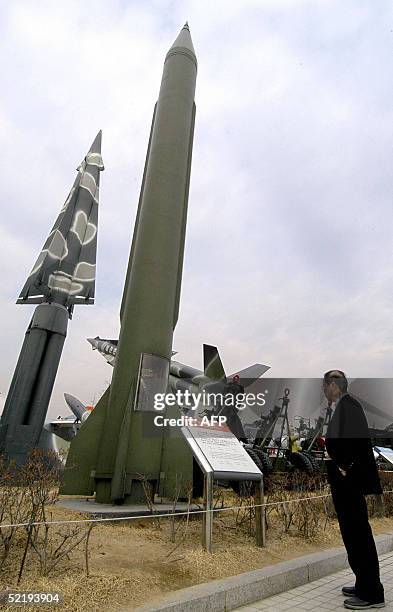 Man looks at a row of scraped missiles on display at the war museum in Seoul, 14 February 2005, including a South Korean Nike missile and a North...