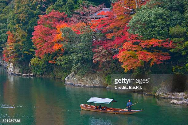 people in a small boat on the hozu river - arashiyama ストックフォトと画像