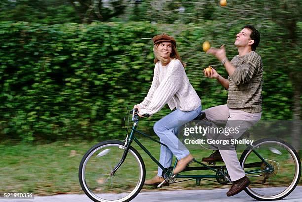 couple biking and juggling - tandem bicycle stock pictures, royalty-free photos & images