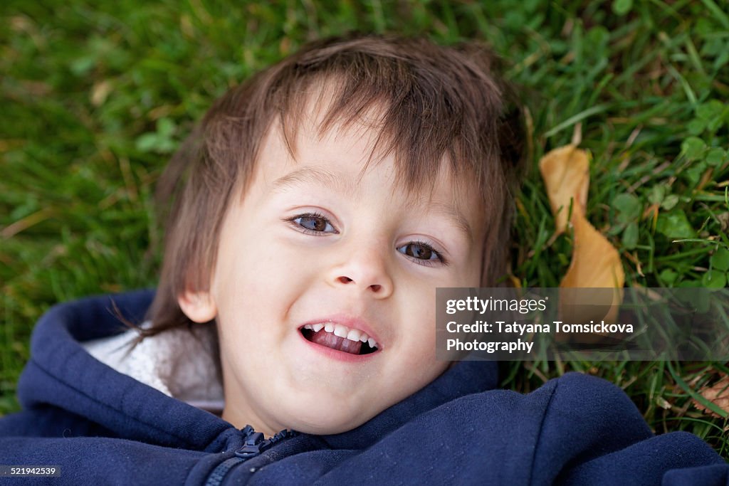 Adorable boy, lying on the grass