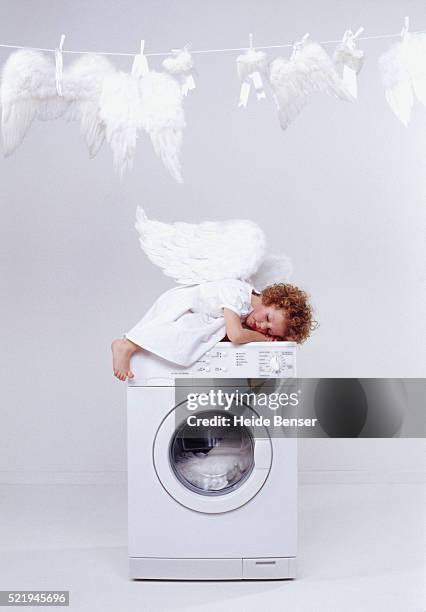 girl in angel costume sleeping on washing machine - sleep hygiene stock pictures, royalty-free photos & images