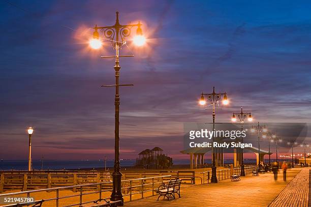 boardwalk on coney island at twilight - coney island stock pictures, royalty-free photos & images