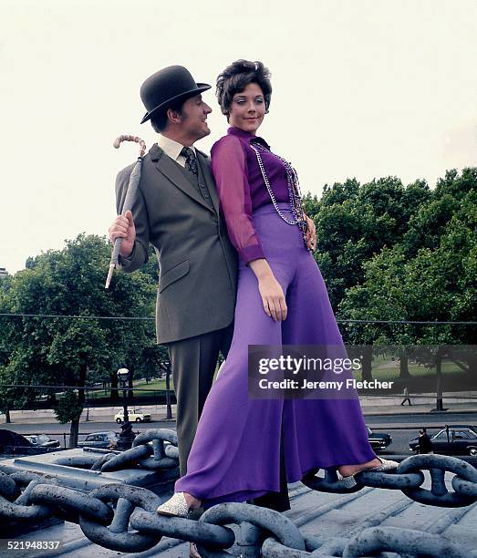English actor Patrick Macnee and Canadian actress Linda Thorson on a boat moored on the River Thames in London, during a publicity photoshoot for the...