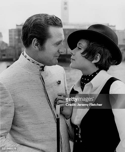 English actor Patrick Macnee and Canadian actress Linda Thorson on a boat moored on the River Thames in London, during a publicity photoshoot for the...