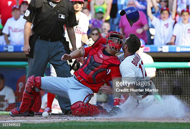 Peter Bourjos of the Philadelphia Phillies scores the game tying run as he collides with Jose Lobaton of the Washington Nationals in the tenth inning...