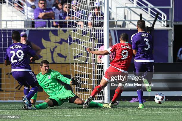 Goalkeeper Joseph Bendik of Orlando City SC makes a kick save against Charlie Davies of New England Revolution during a MLS soccer match at the...