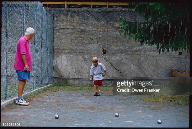 boy and elderly man playing petanque - petanque court stock pictures, royalty-free photos & images