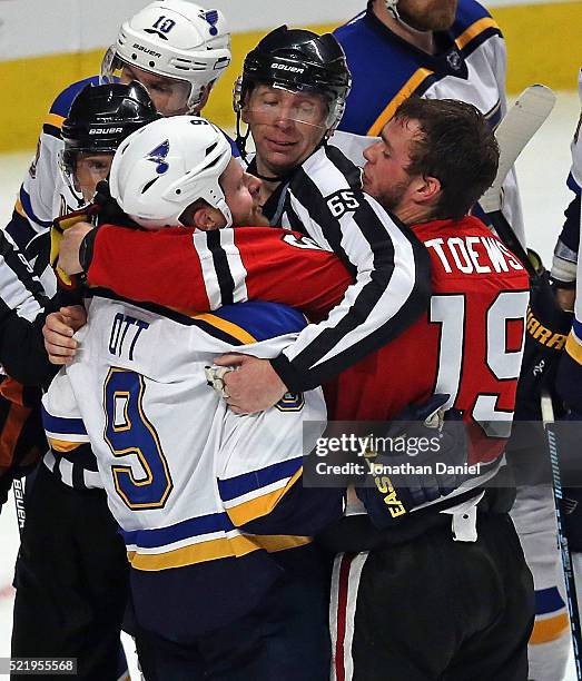 Linesman Pierre Racicot get between Steve Ott of the St. Louis Blues and Jonathan Toews of the Chicago Blackhawks in Game Three of the Western...
