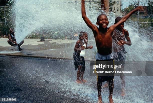 children playing in fire hydrant spray - the bronx foto e immagini stock