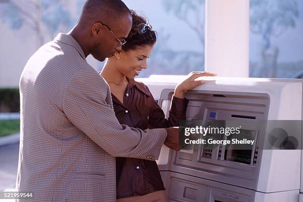 couple at an atm - man atm smile stock pictures, royalty-free photos & images