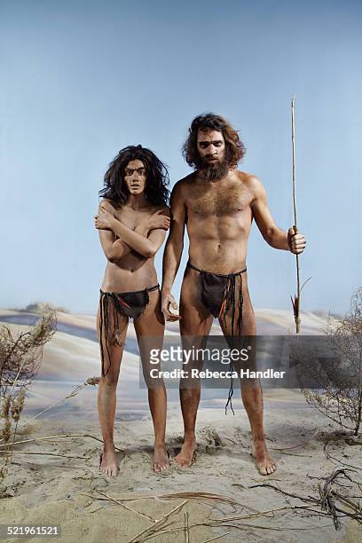 prehistoric man and woman next to each other - lendenschurz stock-fotos und bilder