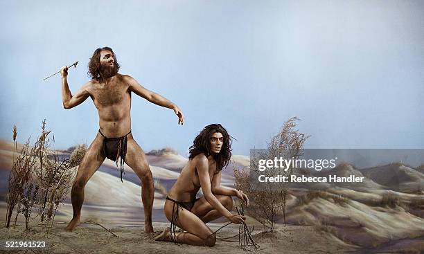 prehistoric man next to  woman kneeling - prehistoric man fotografías e imágenes de stock