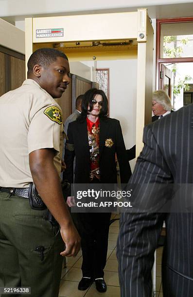 Pop star Michael Jackson enters through security at the courthouse in Santa Maria, California 14 February for the start of another week of jury...