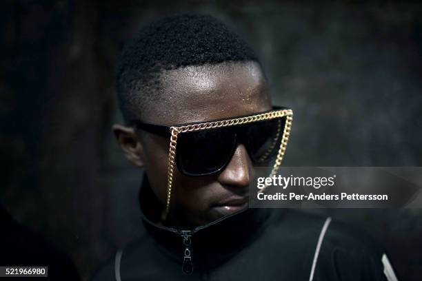 Sapeur dressed up shows his designer label clothes and glasses in Mombele, a suburb on February 12, 2012 in Kinshasa, DRC. The word Sapeur comes from...