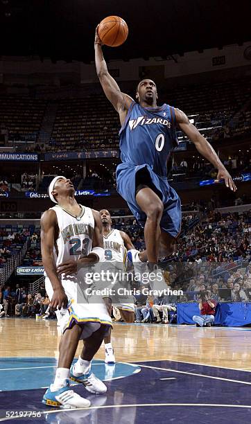 Gilbert Arenas of the Washington Wizards gets past J.R. Smith of the New Orleans Hornets for a dunk on February 14, 2005 at the New Orleans Arena in...