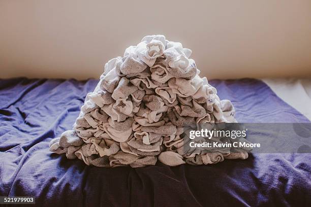 stack of socks on top of bed - sock stock pictures, royalty-free photos & images