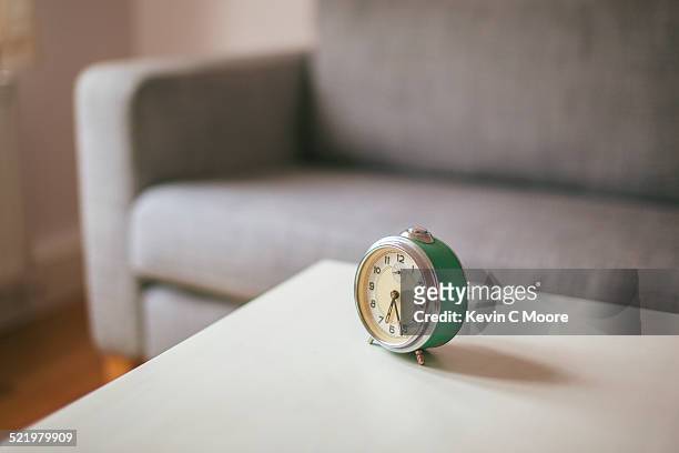 alarm clock on coffee table in living room - mesa baja de salón fotografías e imágenes de stock