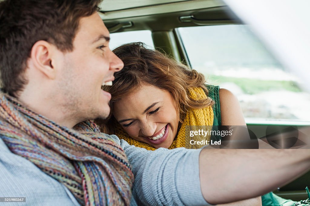 Young couple driving car laughing, Cape Town, Western Cape, South Africa