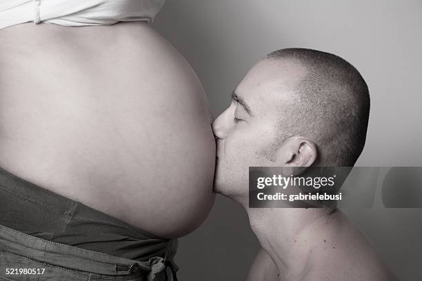 man kissing pregnant woman's stomach - belly kissing stock pictures, royalty-free photos & images