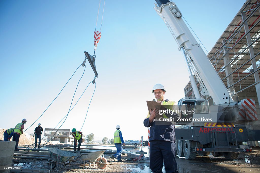 Site manager with clipboard on construction site