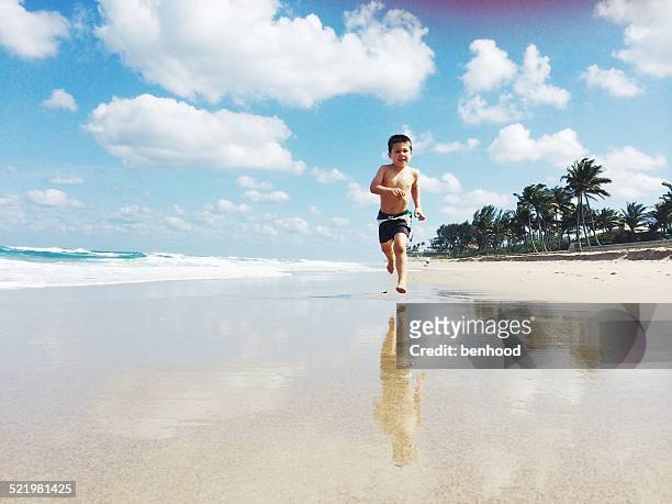 usa, florida, palm beach county, west palm beach, boy (2-3) running on beach - west palm beach foto e immagini stock