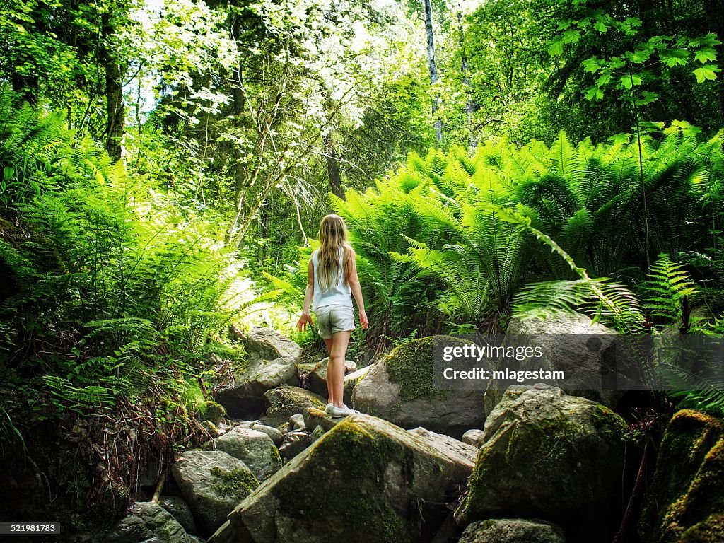 Sweden, Girl (8-9) standing in forest