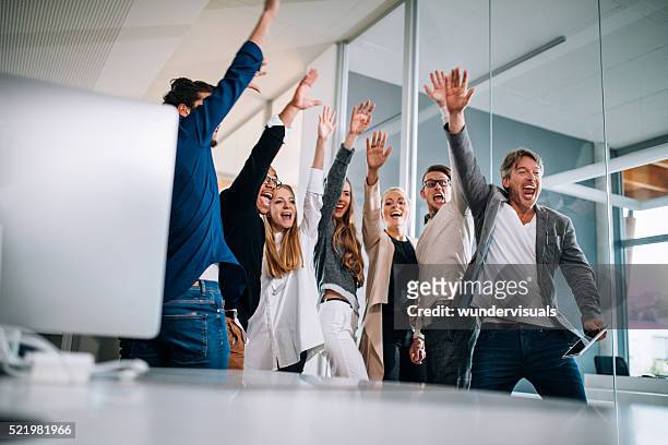 multi-ethnic group of start up colleagues celebrating successful presentation pitch. - cheering stock pictures, royalty-free photos & images