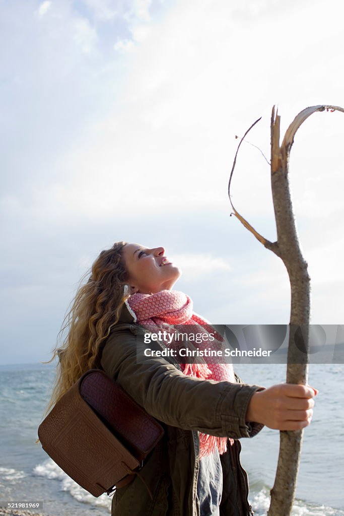 Woman by the sea with a large stick