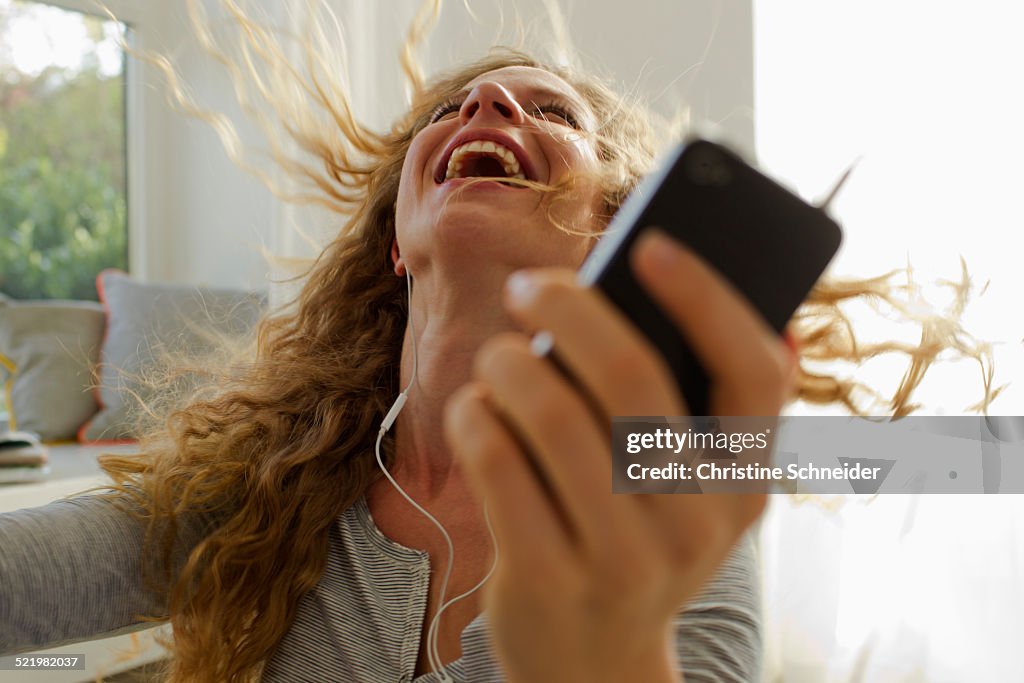 Woman dancing to music on smartphone