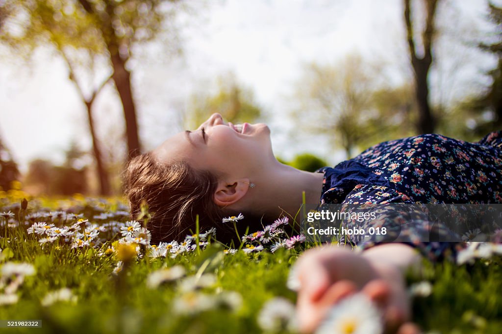 Pretty young teenage girl relaxing on a grass