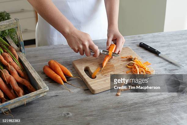 hands of teenage girl peeling carrots on kitchen counter - éplucher photos et images de collection
