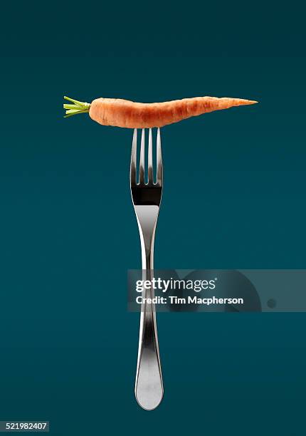 still life of fresh carrot on top of fork - carrot isolated stock pictures, royalty-free photos & images