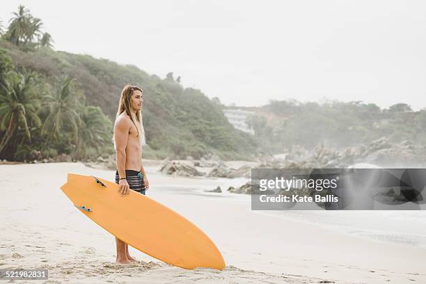 australian surfer with surfboard, bacocho, puerto escondido, mexico - puerto escondido stock pictures, royalty-free photos & images