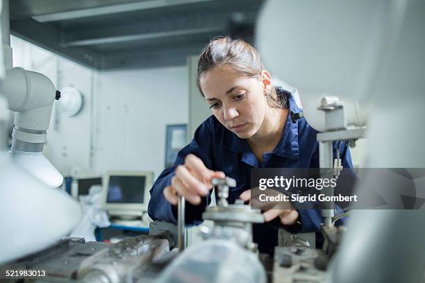 female engineer turning valves on factory industrial piping - single female stock-fotos und bilder