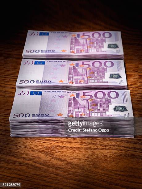 three stacks of 500 euro bills on office desk - five hundred euro banknote stock pictures, royalty-free photos & images