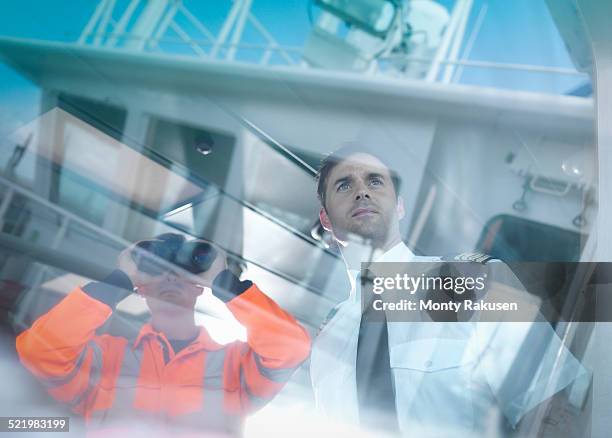 ships captain and worker seen through reflections on container ship - boat captain stock pictures, royalty-free photos & images