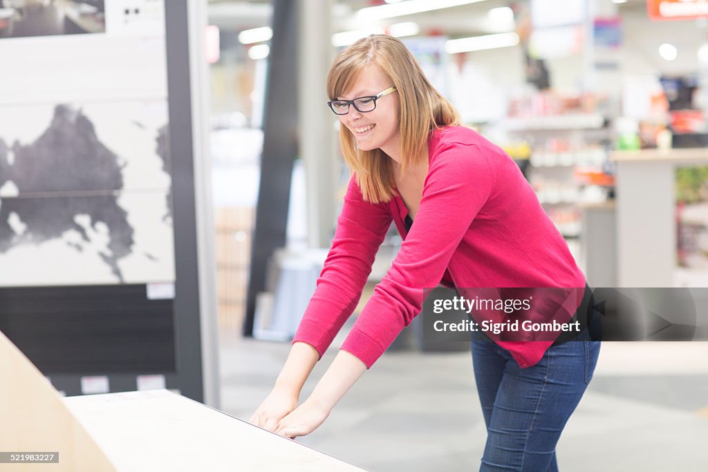 Female customer opening chest of drawers in hardware store