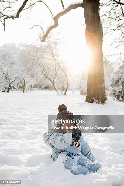 young girl sitting in snow - winter baby stock pictures, royalty-free photos & images