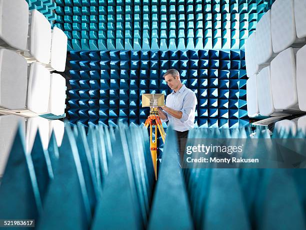 male scientist preparing to measure electromagnetic waves in anechoic chamber - science measurement stock pictures, royalty-free photos & images