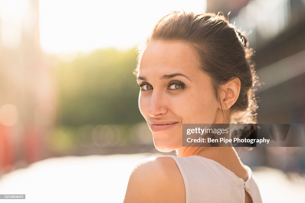 Young woman looking over shoulder towards camera
