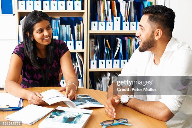 female lecturer having tutorial with male student in college classroom - england training session stock pictures, royalty-free photos & images