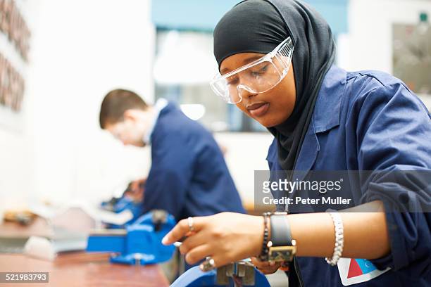female student using vice grip in college workshop - muslim student stock pictures, royalty-free photos & images