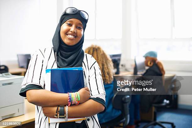 portrait of young female student with file in college classroom - hijab girl stock-fotos und bilder