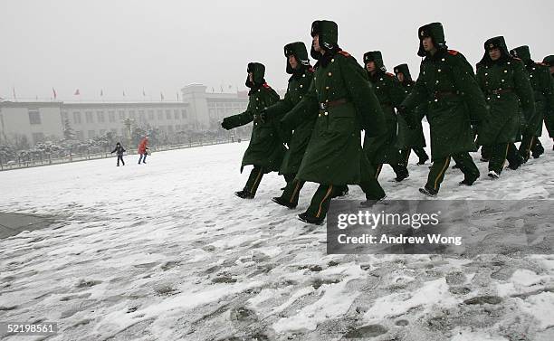 Chinese police march through a snow-covered Tiananmen Square on February 15, 2005 in Beijing, China. Residents woke on February 15 to a sudden...